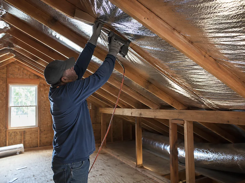 Stapling reflective radiant barrier foil to attic rafters